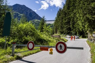 Une vue de la barriere qui ferme la route, suite a l'eboulement de roches proche du barrage de la Grande Dixence le jeudi 17 juillet 2025 depuis Meribe sur la commune d'Heremence en Valais. La Commune d'Heremence annonce qu'en raison d'un important eboulement survenu le samedi 12 juillet 2025 dans le secteur de la Grande Dixence, des mesures de securite immediates ont ete prises, avec la fermeture de l'acces au barrage de la Grande Dixence. Environ 5'000 metres cubes de roches se sont detaches de la falaise surplombant le site. (KEYSTONE/Jean-Christophe Bott)